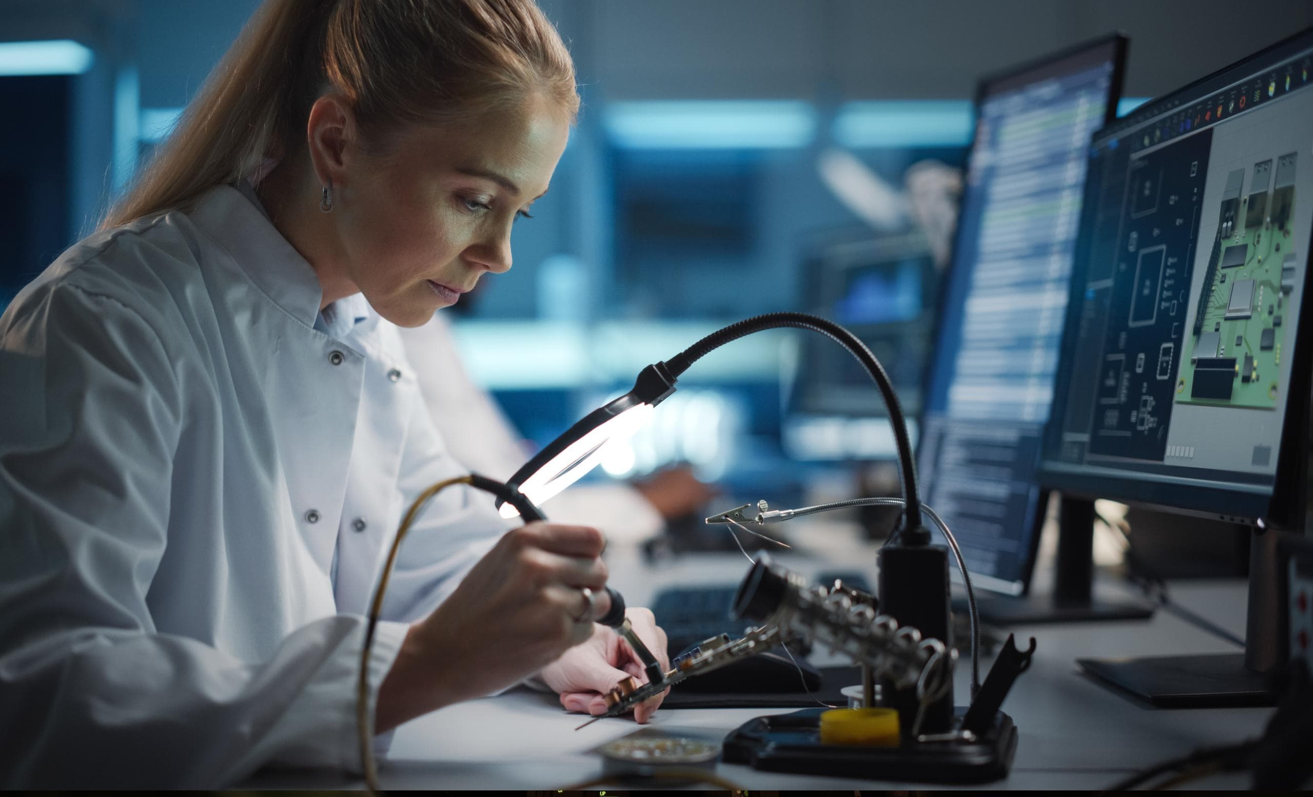 A technician soldering electronics at a workstation