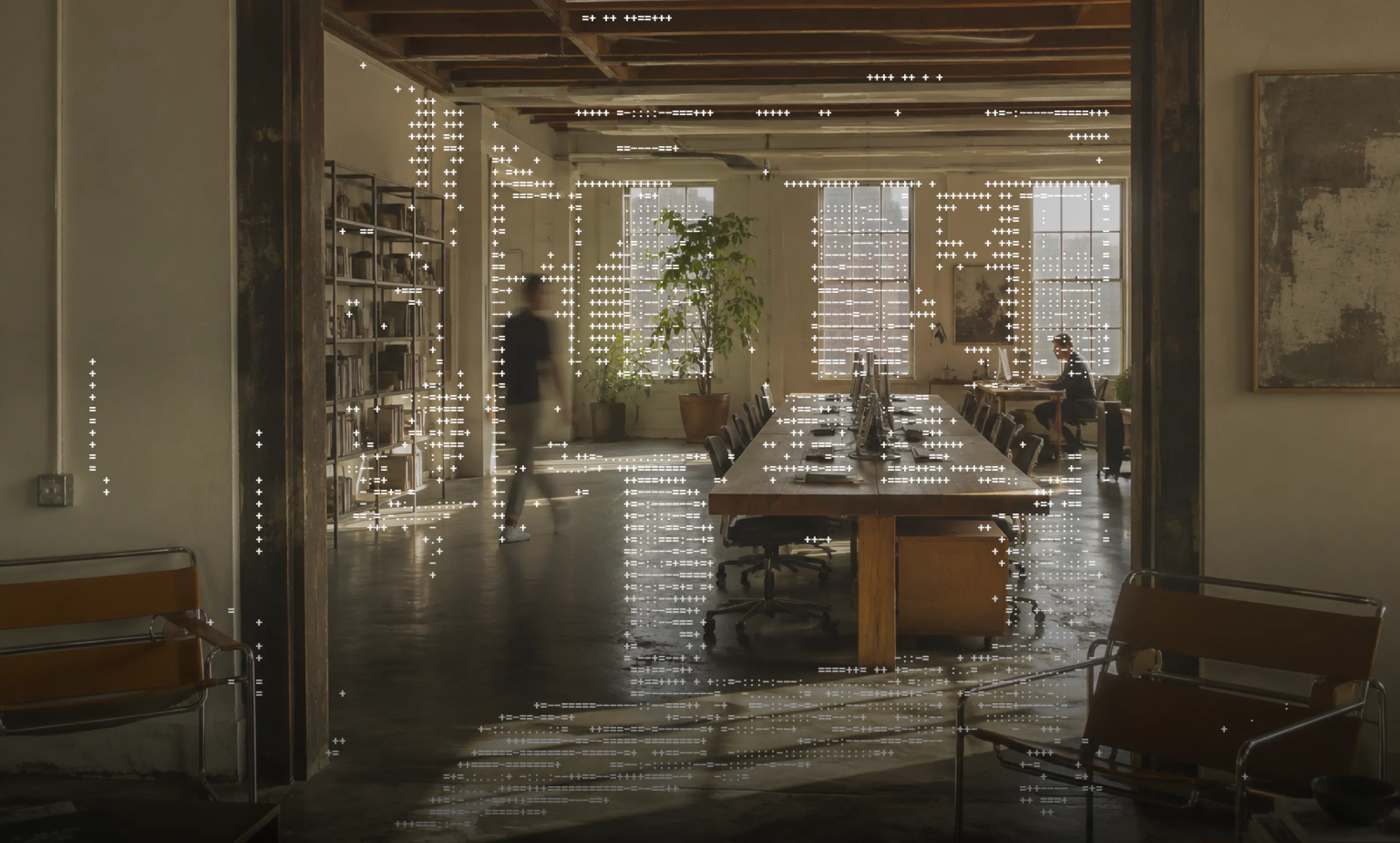 An office with a long shared desk, overlaid with a pattern of text characters